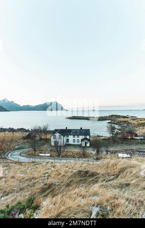 Casa di abitazione remota e cottage sulla proprietà durante l'atmosfera serale, fiordo paesaggio con piccole isole, isolamento dal mondo esterno, Vesteralen, Norvegia Foto Stock