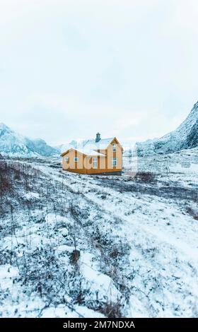 Casa solitaria gialla nel paesaggio innevato in Norvegia, vecchia casa residenziale, casa in legno nella zona del fiordo Foto Stock