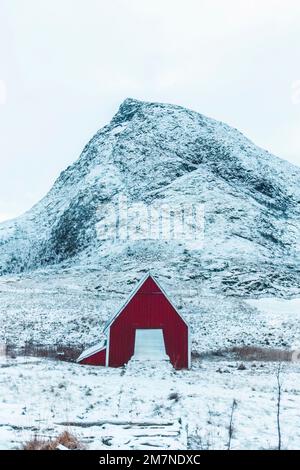 Casa solitaria rossa nel paesaggio innevato in Norvegia, vecchia casa residenziale, casa in legno in zona fiordo Foto Stock