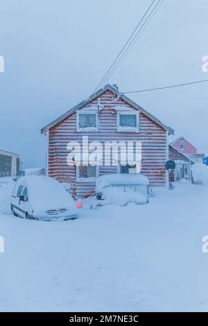 Villaggio di pescatori solitario e nevoso sul fiordo in Norvegia, tipico paesaggio fiordo con neve, isolamento dal mondo esterno Foto Stock