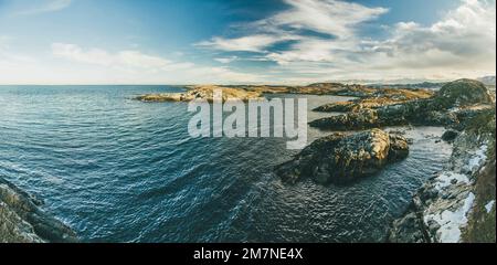 Immagine panoramica del tipico paesaggio fiordo con piccole isole in Norvegia. Paesaggio costiero nordico con rocce, mare e surf sulla costa Foto Stock