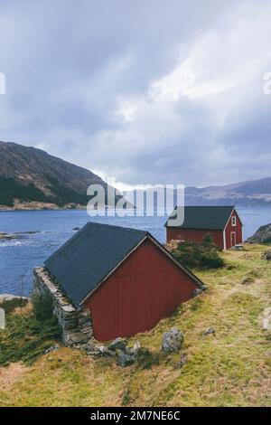 Solitario cottage di pesca sul fiordo in Norvegia, tipico paesaggio fiordo con piccole isole, isolamento dal mondo esterno, casa sul lago Foto Stock