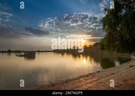 Sole si trova dietro l'ingresso principale del lago Gadisar, Jaisalmer, Rajasthan, India. Lago artificiale storico, una volta sola risorsa idrica per la città di Jaisalmer. Foto Stock
