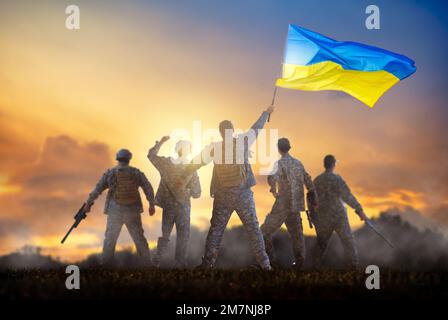 Guerra in Ucraina. Soldato con bandiera Ucraina torna a casa. Patriot celebra la vittoria. Gloria all'Ucraina, gloria agli eroi. Foto Stock