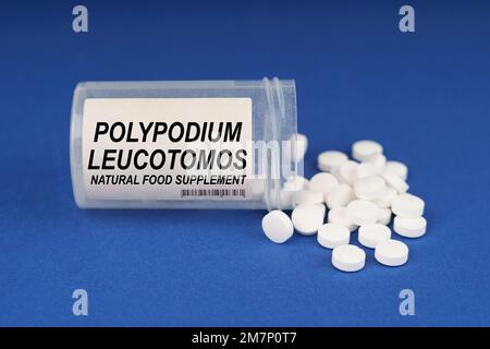 Il concetto di farmacologia e salute. Su una superficie blu sono le pillole e un vaso polveroso con l'iscrizione - Polypodium Leucocomos Foto Stock
