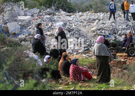 Salfit, Palestina. 10th Jan, 2023. Una famiglia palestinese è vista vicino ai detriti della loro casa distrutta nel villaggio di Kafr al-Dik, vicino a Salfit, nella Cisgiordania occupata. L'esercito israeliano ha demolito una casa appartenente a una famiglia palestinese, con il pretesto di non ottenere un permesso. (Foto di Nasser Ishtayeh/SOPA Images/Sipa USA) Credit: Sipa USA/Alamy Live News Foto Stock