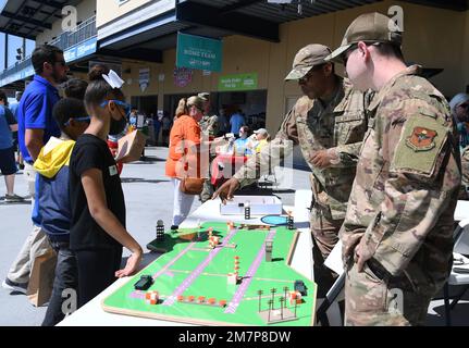 STATI UNITI Tecnologia Air Force. Shawn Nunnally, 334th istruttore di Squadron di formazione, e il personale Sgt. Zachary Jansen, 334th sviluppatore di curriculum di Squadron di formazione, forniscono un briefing sulle attrezzature radar per il campo aereo e i sistemi meteorologici agli studenti della Scuola elementare centrale di Gulfport durante l'evento Biloxi Shuckers Education Day a Biloxi, Mississippi, 11 maggio 2022. L'evento ha permesso agli Airmen del 81st Training Group di allestire allestimenti per l'addestramento dei bambini in età scolare locali da visualizzare durante la partita dei Biloxi Shuckers. Foto Stock