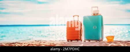 Vista panoramica del mare con valigie sulla spiaggia di sabbia. Foto Stock