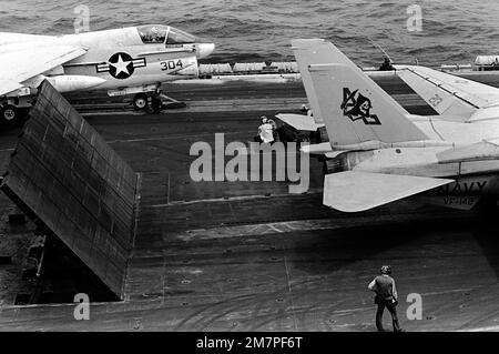 Durante 142 le operazioni di volo a bordo della portaerei a energia nucleare USS DWIGHT D. EISENHOWER (CVN-69), dietro un aereo F-14 Tomcat vengono sollevati tre pannelli deflettori di blasto. 142 Un aereo Corsair II a-7E da Light Attack Squadron 66 (VA-66) è attaccato ad una catapulta a vapore sullo sfondo. Seconda vista in una serie di otto. Base: USS Dwight D Eisenhower (CVN 69) Foto Stock