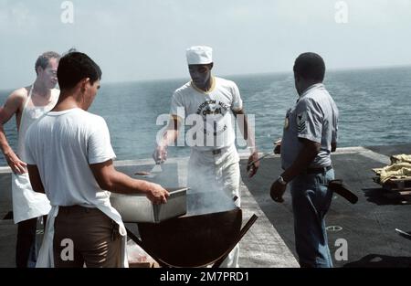 Gli equipaggi a bordo della portaerei USS MIDWAY (CV 41) hamburger grigliati sul ponte di volo durante un periodo di attesa. Paese: Oceano Pacifico (POC) Foto Stock