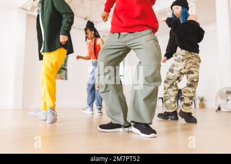 Immagine della sezione bassa del gruppo di diverse ballerine hip hop femminili e maschili in studio Foto Stock