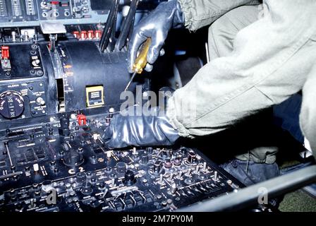 Un membro dell'equipaggio del 436th Avionics Maintenance Squadron, vestito con attrezzi da guerra chimica, esegue la manutenzione sul pannello di controllo nell'abitacolo di un velivolo C-5A Galaxy durante un test di equipaggiamento per la difesa da guerra chimica. Base: Dover Air Force base Stato: Delaware (DE) Paese: Stati Uniti d'America (USA) Foto Stock