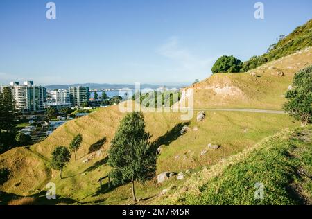 Pendenza del Monte Maunganui con percorso a piedi e porto e città sullo sfondo, Tauranga Nuova Zelanda. Foto Stock