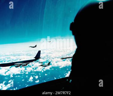 Vista laterale destra di un velivolo Stratotanker KC-135 e di un velivolo Falcon combattente F-16A, visto dall'interno della tettoia di un altro Falcon, in volo. Il KC-135 rifornisce uno degli aerei durante lo schieramento alla base aerea di Kunsan, Corea. I Falconi sono tratti dallo Squadrone Tactical Fighter 35th, dalla 8th Tactical Fighter Wing. Paese: Oceano Pacifico (POC) Foto Stock