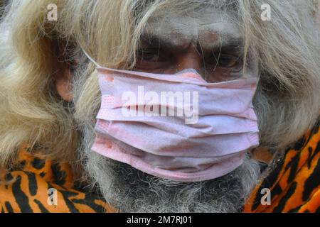 Kolkata, India. 11th Jan, 2023. Un Sadhu o un santo indù, che indossa una maschera in un rifugio di fortuna prima di dirigersi per un viaggio annuale all'Isola di Sagar per il festival di un giorno di 'Makar Sankranti', a Kolkata. (Foto di Sudipta Das/Pacific Press) Credit: Pacific Press Media Production Corp./Alamy Live News Foto Stock