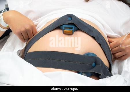 Ripresa di una donna incinta irriconoscibile sdraiata nel letto dell'ospedale alla data di scadenza Foto Stock