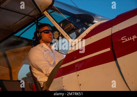 Un giovane pilota maschio con un Piper Super Cub Foto Stock