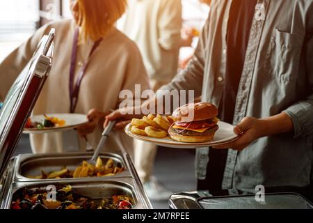 Uomo che raccoglie cibo a un piatto in un buffet in un hotel Foto Stock