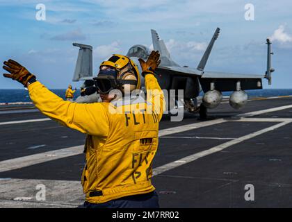 Mare delle Filippine, acque internazionali. 10th Jan, 2023. Mare delle Filippine, acque internazionali. 10 gennaio 2023. NEGLI STATI UNITI Il direttore del ponte di volo della Marina segnala a un aereo da combattimento F/A-18E Super Hornet, da tenere in taxi sul ponte di volo della portaerei di classe Nimitz USS Nimitz, 10 gennaio 2023 operante nel Mare delle Filippine. Credit: MC3 Joseph Calabrese/US Navy/Alamy Live News Foto Stock