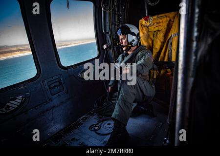 OCEANO PACIFICO (12 maggio 2022) - Naval Aircrewman (elicottero) 1st Class Joshua Kugh partecipa a un volo di riascolto in un falco marino MH-60s attaccato a Helicopter Sea Combat Squadron (HSC) 3. HSC-3 è lo squadrone di sostituzione della flotta della Marina della costa occidentale MH-60s, responsabile della formazione di piloti e equipotenti fornendo i combattenti più capaci alla flotta. Foto Stock