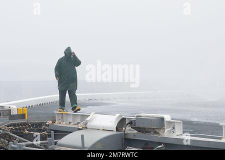 220512-N-IL330-2135 OCEANO PACIFICO (12 maggio 2022) – il Fireman Jonny Ruiz, di New York, controlla gli ugelli durante un lavaggio in contromisura sul ponte di volo a bordo del vettore d'assalto anfibio USS Tripoli (LHA 7), 12 maggio 2022. Tripoli sta conducendo operazioni di routine nella U.S. 3rd Fleet. Foto Stock