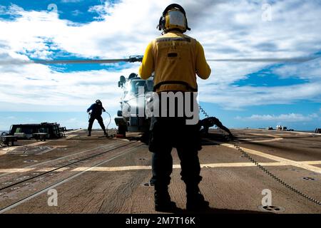 MARE DELLE FILIPPINE (12 maggio 2022) Boatswain’s Mate 2nd Class Jewlian Wilson, di Jacksonville, FLA, segnala un elicottero MH-60R Sea Hawk, assegnato ai “Raptors” dell’elicottero Maritime Strike Squadron (HSM) 71, sul ponte di volo del cacciatorpediniere missilistico guidato di classe Arleigh Burke USS Spruance (DDG 111) mentre Michael Blanchan, lasciò la nave Da Panama City Beach, Fla., e il compagno di Boatswain Seaman Alvin Moe, a destra, da New York, attaccate dei cunei e delle catene. Abraham Lincoln Strike Group è in fase di implementazione pianificata nell'area operativa della flotta 7th degli Stati Uniti per migliorare l'interoperabilità attraverso alleanze Foto Stock