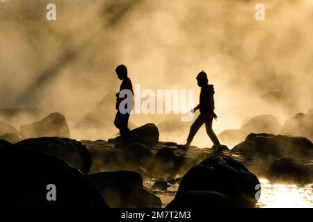 8 gennaio 2023; sorgenti termali calde e nebbia in Thailandia con luce del sole mattutina. Atmosfera mattutina al Parco Nazionale di Chae Son, sagome di turisti godendo Foto Stock