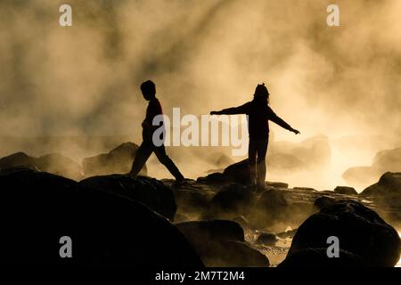 8 gennaio 2023; sorgenti termali calde e nebbia in Thailandia con luce del sole mattutina. Atmosfera mattutina al Parco Nazionale di Chae Son, sagome di turisti godendo Foto Stock