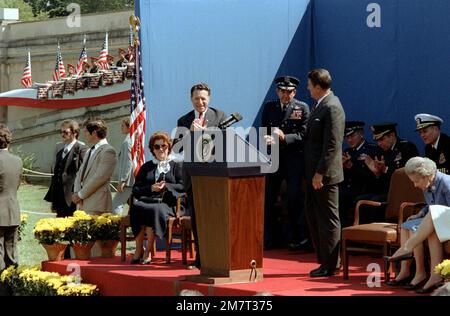 Il presidente Ronald Reagan parla ad un'udienza durante una cerimonia per la dedicazione del corridoio di GEN Douglas MacArthur del Pentagono. Il Segretario della Difesa Caspar W. Weinberger si trova a sinistra, mentre al centro si trovano i Capi congiunti del PRESIDENTE DEL PERSONALE GEN David C. Jones. La signora MacArthur si trova sulla destra. Base: Arlington Stato: Virginia (VA) Nazione: Stati Uniti d'America (USA) Foto Stock