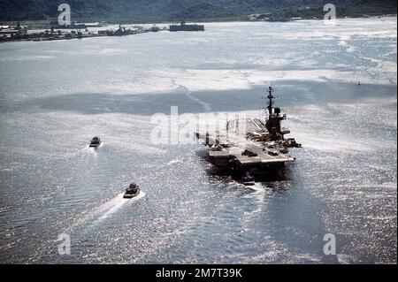 Una vista in alto a poppa della portaerei USS MIDWAY (CV-41) che entra nella Subic Bay scortata da tre rimorchiatori. Paese: Filippine (PHL) Foto Stock