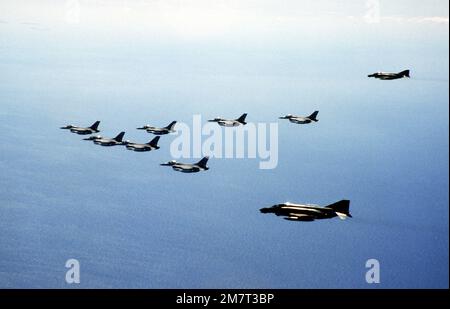 Una vista dal lato sinistro aria-aria di sette aerei F-16 Fighting Falcon scortati da due aerei F-4D Phantom II (posteriori), in rotta verso il loro nuovo comando con la 8th Tactical Fighter Wing. Base: KUNSAN Air base Nazione: Repubblica di Corea (KOR) Foto Stock