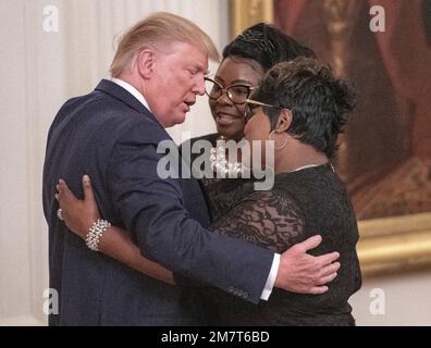 **FILE PHOTO** il diamante del duo Pro Trump Diamond and Silk è scomparito su 51. Il presidente degli Stati Uniti Donald J. Trump abbraccia Diamond e Silk mentre li menziona durante le sue osservazioni al Summit Presidenziale sui social media nella Sala Est della Casa Bianca a Washington, DC giovedì 11 luglio 2019. Credit: Ron Sachs/CNP /MediaPunch Foto Stock