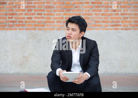 Uomo d'affari in difficoltà di perdita di posti di lavoro a causa della recessione economica e l'inflazione. Foto Stock