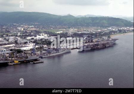 Una vista di quarto del porto della portaerei USS KITTY HAWK (CV-63) ancorata nel porto con l'incrociatore missilistico guidato USS STERETT (CG-31), il cacciatorpediniere USS INGERSOLL (DD-990) e gli olieri USNS MISPILLION (T-AO-105) e USNS NAVASOTA (T-AO-106) ancorati a poppa. Base: Naval Station, Subic Bay Stato: Luzon Paese: Filippine (PHL) Foto Stock