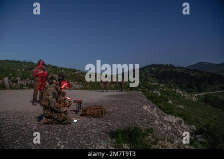 Un membro delle forze operative speciali (SOF) slovene utilizza la visione notturna per visualizzare un bersaglio su una gamma durante l'addestramento del controller di attacco terminale congiunto (JTAC) vicino a Pocek, Slovenia, 12 maggio 2022. L'esercizio congiunto con gli Stati Uniti Il SOF del 10th Special Forces Group, il SOF croato e il SOF sloveno hanno permesso agli operatori JTAC di vedere un bersaglio e di comunicare le informazioni di targeting con un overhead pilota. Exercise Trojan Footprint è il principale esercizio delle forze operative speciali in Europa che si concentra sulla promozione della disponibilità militare, sulla coltivazione della fiducia e sullo sviluppo di relazioni durature che promuovono Foto Stock