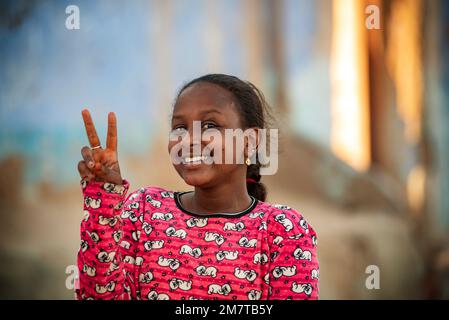 Assuan, Egitto. Dicembre 10th 2022 Pretty felice ragazza nubiana sorridente nel Nilo lato Nubian Village vicino Assuan in Alto Egitto, Africa. Foto Stock