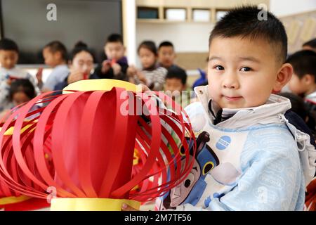 LIANYUNGANG, CINA - 11 GENNAIO 2023 - Un bambino mostra una lanterna in un asilo nido a Lianyungang, nella provincia di Jiangsu della Cina orientale, il 11 gennaio 2023. Foto Stock