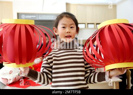 LIANYUNGANG, CINA - 11 GENNAIO 2023 - Un bambino mostra una lanterna in un asilo nido a Lianyungang, nella provincia di Jiangsu della Cina orientale, il 11 gennaio 2023. Foto Stock