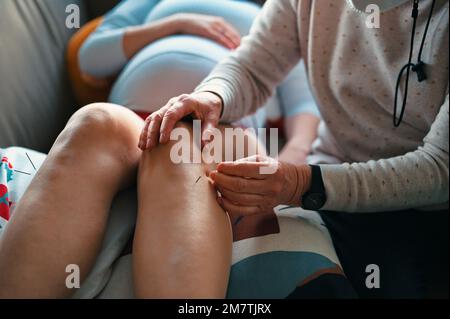 Donna incinta in trattamento di agopuntura Foto Stock