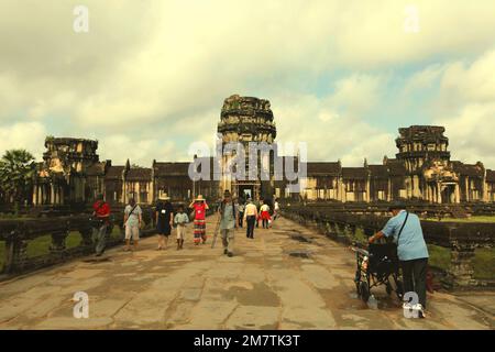 Turisti a piedi sulla passerella che collega Angkor Wat tempio e la struttura esterna a Siem Reap, Cambogia, in questa foto scattata nel 2013. L'anno scorso (2022), Angkor ha accolto 287.454 turisti internazionali, guadagnando 11,5 milioni di dollari USA dalle vendite di biglietti, secondo lo stato di proprietà Angkor Enterprise in un comunicato stampa citato da Xinhua il 5 gennaio 2023. "Attualmente, Angkor attrae tra 1.800 e 2.000 visitatori stranieri al giorno, un aumento significativo da soli 70 al giorno durante la pandemia nel 2020 e 2021", ha affermato il Segretario di Stato del Ministero del Turismo cambogiano, Top Sopheak. Foto Stock