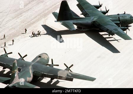 I membri dell'equipaggio trasportano una 'vittima' ad un aereo C-130 Hercules da un ospedale trasportabile aereo durante l'esercitazione ferita Eagle '82. L'altro Ercole è in primo piano. Entrambi gli aerei sono assegnati alla 146th Tactical Airlift Wing, California Air National Guard. Oggetto operazione/Serie: FERITO EAGLE '82 base: Fort Irwin Stato: California (CA) Paese: Stati Uniti d'America (USA) Foto Stock