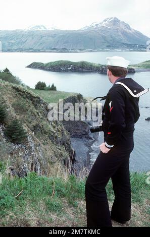 L'ospedale Corpsman 3rd Class William Loftis gode della vista delle montagne innevate sullo sfondo, e l'acqua blu incontra le verdi colline in primo piano. Paese: Stati Uniti d'America (USA) Foto Stock