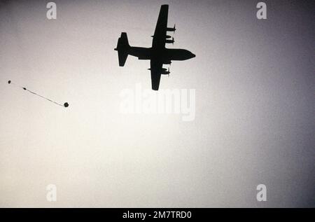 Vista da terra ad aria di un velivolo C-130 Hercules che cade un pallet contenente due fusti d'acqua da 55 litri, sopra la zona di caduta di Fuji in paracadute. Base: Marina Corps base, Camp Fuji Stato: Honshu Paese: Giappone (JPN) Foto Stock