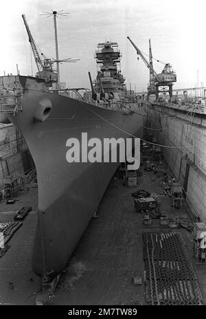 Una vista di prua del porto della nave da guerra NEW JERSEY (BB-62) come si siede nel bacino di carenaggio a secco in fase di rimontaggio e modernizzazione per il ritorno al servizio attivo rimessa in servizio all'inizio del 1983. La nave è in bacino di carenaggio dal novembre 1981. La rimessa in servizio sarà la quarta volta dalla costruzione della nave nel 1942. Base: Long Beach Naval Shipyard Stato: California (CA) Paese: Stati Uniti d'America (USA) Foto Stock