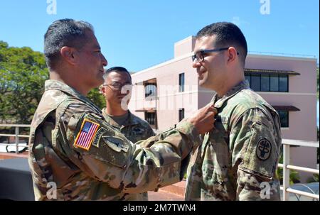 Bill Soliz, comandante del Tripler Army Medical Center, spilla la Meritorious Service Medal dell'esercito sul Major Salvator Mignano, patologo, TAMC, durante una cerimonia al TAMC, 13 maggio 2022. Foto Stock