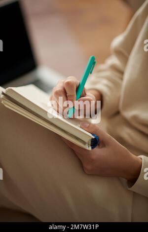 Immagine di primo piano di una donna che scrive nel giornale di gratitudine o pianificatore Foto Stock