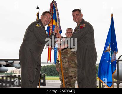 Steven Massie II, comandante uscente 36th Airlift Squadron, a destra, passa una guida al col. Kevin Martin, comandante del gruppo operativo 374th, durante la cerimonia di cambio di comando 36th Airlift Squadron, il 13 maggio 2022, alla base aerea di Yokota, Giappone. Il passaggio del guidon significa Massie che cede il comando del 36th AS. Foto Stock