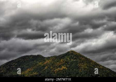 Nuvole cupe e tempestose sopra la cima della collina. Paese autunno Foto Stock