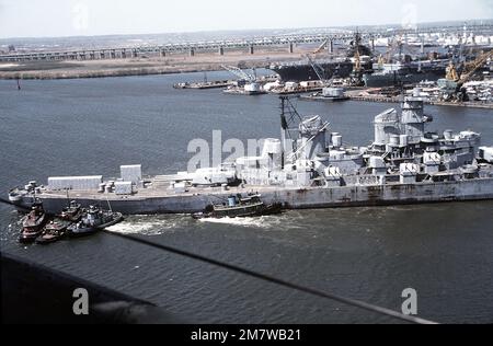 Vista aerea a dritta della corazzata IOWA (BB-61) manovrata dai rimorchiatori dal suo ormeggio per la pallina. L'IOWA è stata spostata in preparazione della modernizzazione, della riattivazione e della rimessa in servizio nel gennaio 1985. Base: Philadelphia Stato: Pennsylvania (PA) Paese: Stati Uniti d'America (USA) Foto Stock