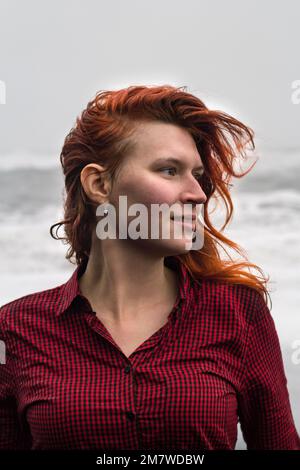 Primo piano attraente donna in camicia rossa ritratto esterno Foto Stock